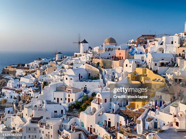 classic cityscape of oia at sunset - oia santorini stock pictures, royalty-free photos & images