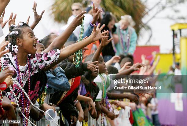 Children call for beads during the Gulf Coast Carnival Association/Neptune Mardi Gras parade in Biloxi, Mississippi, Tuesday, February 5, 2008.