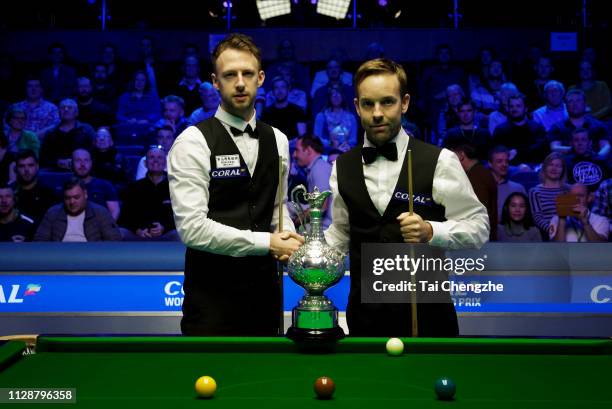 Ali Carter of England and Judd Trump of England shake hands during their final match on day 7 of the 2019 Coral World Grand Prix at The Centaur on...