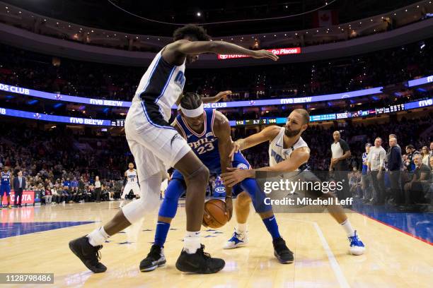 Jimmy Butler of the Philadelphia 76ers controls the ball against Jonathan Isaac and Evan Fournier of the Orlando Magic in the fourth quarter at the...