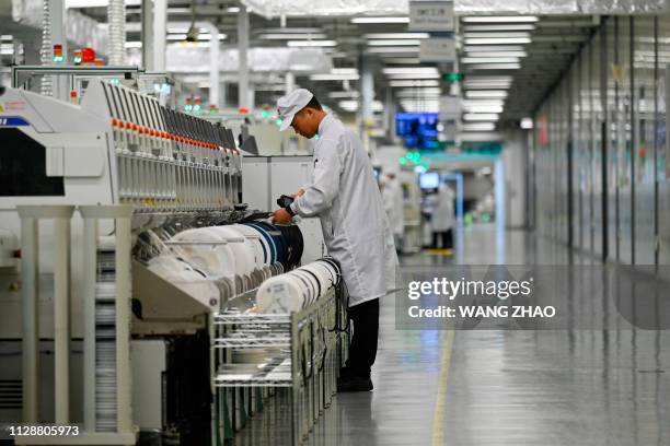 An employee works on a mobile phone production line at a Huawei production base during a media tour in Dongguan, China's Guangdong province on March...