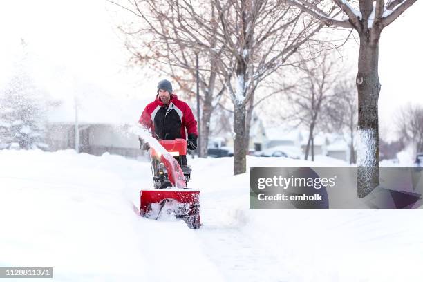 man using snow blower on winter day - snow blower stock pictures, royalty-free photos & images