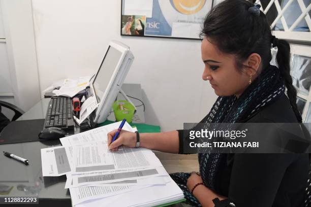 Woman fills an application for Italy's new Citizen's Income at a tax service center in Rome on March 6, 2019. - Italys governing Five Star Movement...