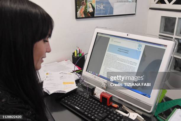 An employee of a tax service center gets prepared to assist applicants for Italy's new Citizen's Income in Rome on March 6, 2019. - Italys governing...