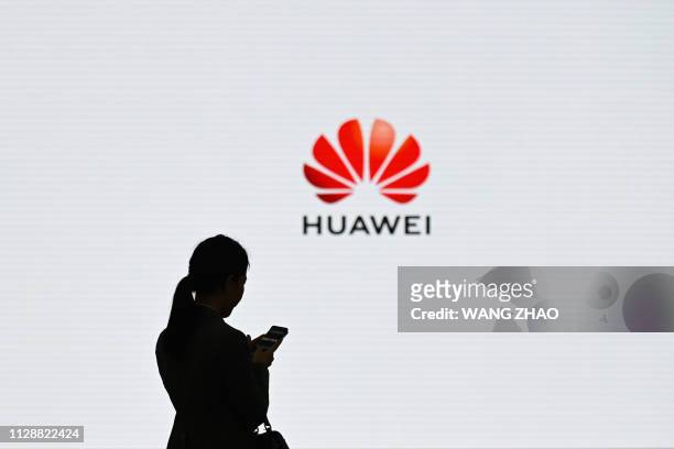 Staff member of Huawei uses her mobile phone at the Huawei Digital Transformation Showcase in Shenzhen, China's Guangdong province on March 6, 2019....