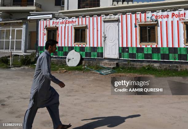 Pakistani man walks past a closed medical dispensary and offices of the Falah-e-Insaniat Foundation -- an organisation believed by the UN to be a...