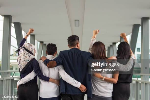 heckansicht des unkenntlich business team mit waffen um einander - arm umlegen stock-fotos und bilder