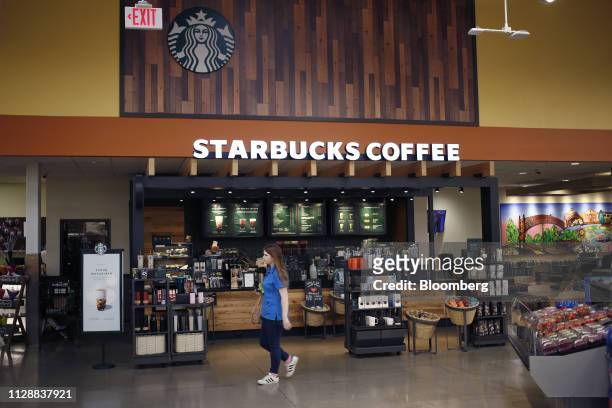 An employee passes in front of a Starbucks Corp. Coffee location inside a Kroger Co. Supermarket in Louisville, Kentucky, U.S., on Tuesday, March 5,...