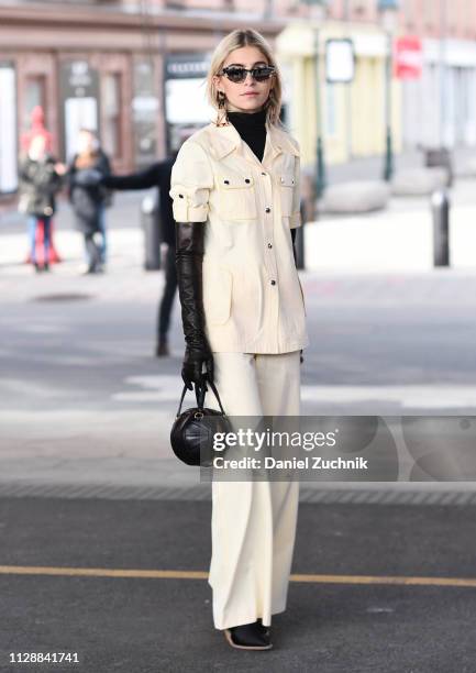 Caroline Daur is seen wearing a cream top and pants with a black purse outside the Tory Burch show during New York Fashion Week: Fall/Winter 2019 on...