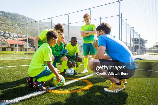 coach talking to soccer players - coacha photos et images de collection