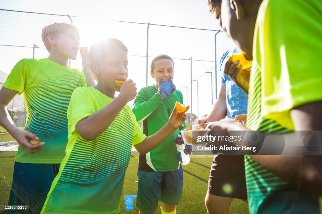 Boys soccer team eating oranges at half time