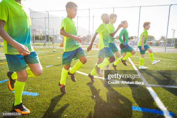 boys soccer team warming up - warm up exercise stockfoto's en -beelden