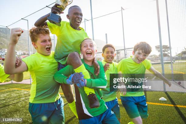 boys soccer team celebrating with trophy - teen awards stock-fotos und bilder