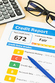 Fair credit score report with pen and calculator; document and the report are mocked-up