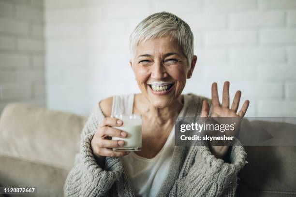 fröhlich, reife frau mit milch schnurrbart blick in die kamera. - milchbart stock-fotos und bilder