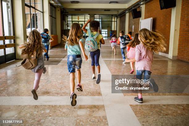 rückansicht der gruppe von schulkindern durch den flur laufen. - end stock-fotos und bilder