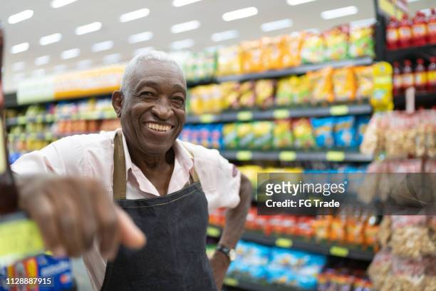 de eigenaar van het bedrijf van de afro senior man / werknemer bij supermarkt - retail occupation stockfoto's en -beelden