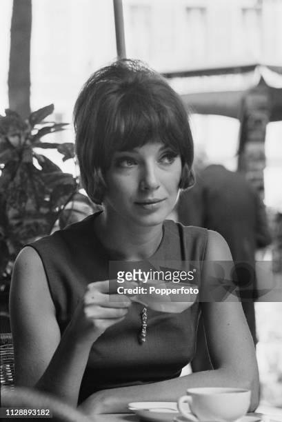 Canadian fashion model and actress Joanna Shimkus pictured drinking a cup of coffee in a cafe in Paris, France in August 1963.