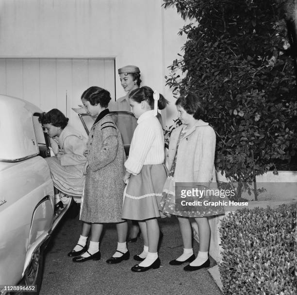 American actress Natalie Wood letting her sister Lana Wood and her friends entering a car, US, 6th January 1956.