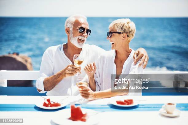 toast to the summer. - older couple hugging on beach stock pictures, royalty-free photos & images