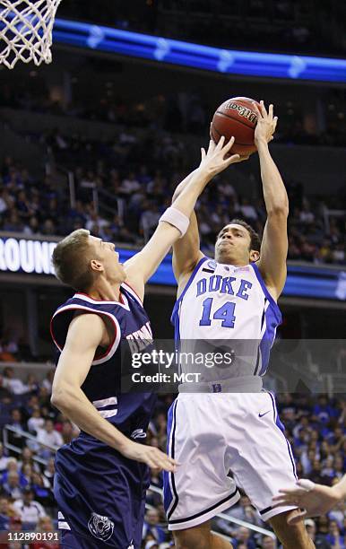Belmont's Keaton Blecher gets a hand on a shot by Duke's David McClure during first half action as the Duke Blue Devils faced the Belmont Bruins in...