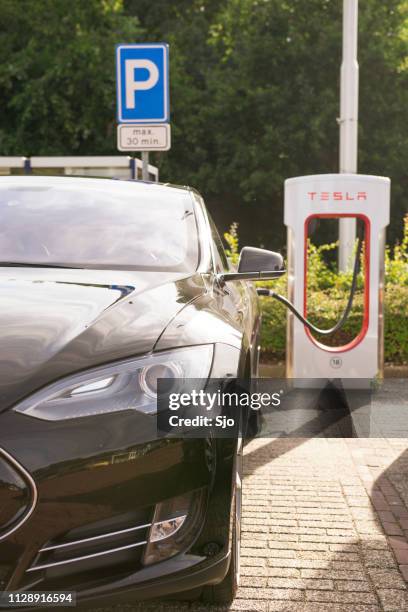 tesla model s electric car at a supercharger charging station - tesla model s stock pictures, royalty-free photos & images