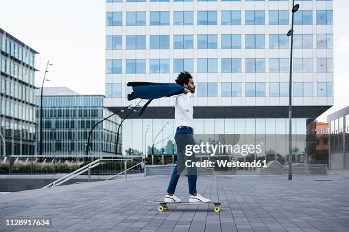 Spain, Barcelona, young businessman riding skateboard in the city Spain, Barcelona, young businessman riding skateboard in the city