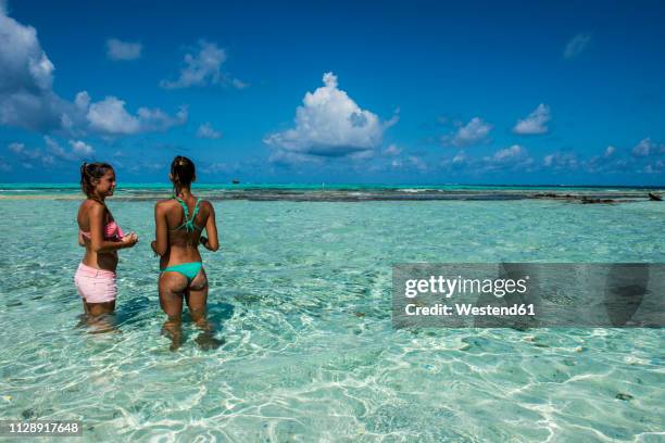 carribean, colombia, san andres, el acuario, two women standing in shallow turquoise water - san andres stockfoto's en -beelden