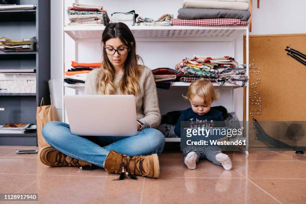 mother and little daughter sitting on the floor at home using laptop and tablet - imitation stock photos et images de collection