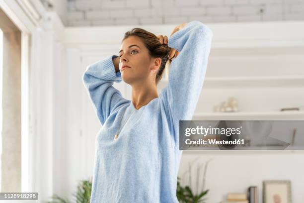 pensive young woman wearing pullover - touching hair stock pictures, royalty-free photos & images