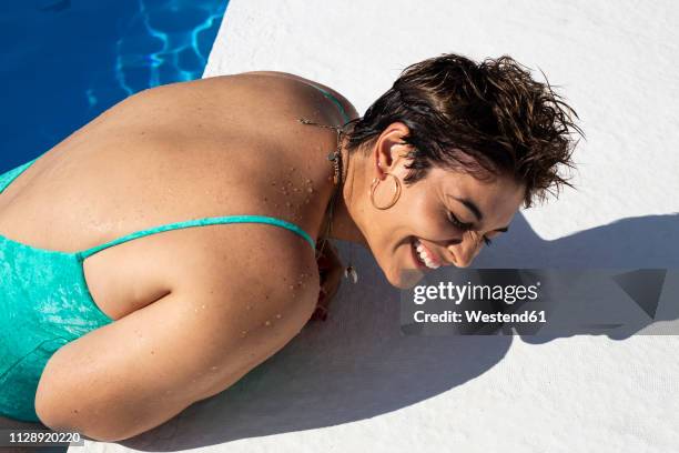 laughing young woman leaning at poolside - voluptuous ladies photos et images de collection