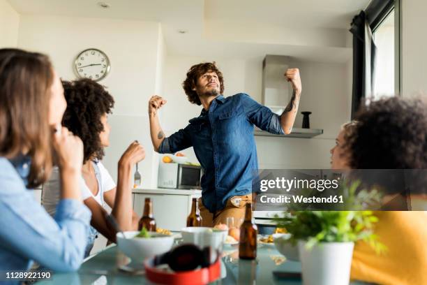 woman sitting at dining table watching man posing - hero and not superhero fotografías e imágenes de stock