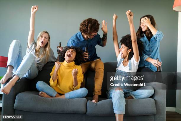 excited fans watching tv and cheering - friends cheering stock pictures, royalty-free photos & images