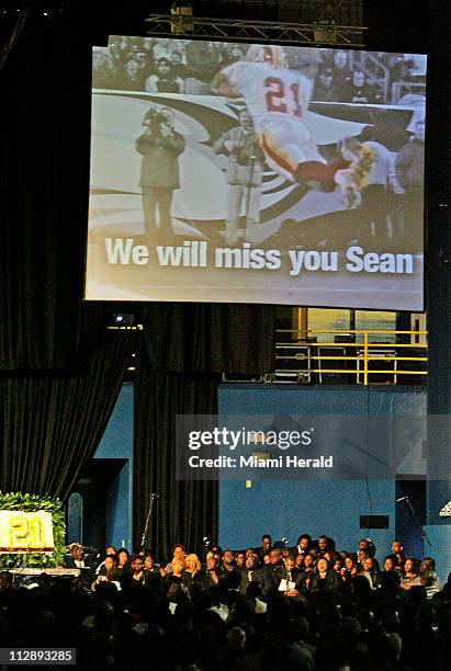 An image from a video tribute plays above the gathered mourners at the Sean Taylor funeral service at the Pharmed Arena in the campus of Florida...