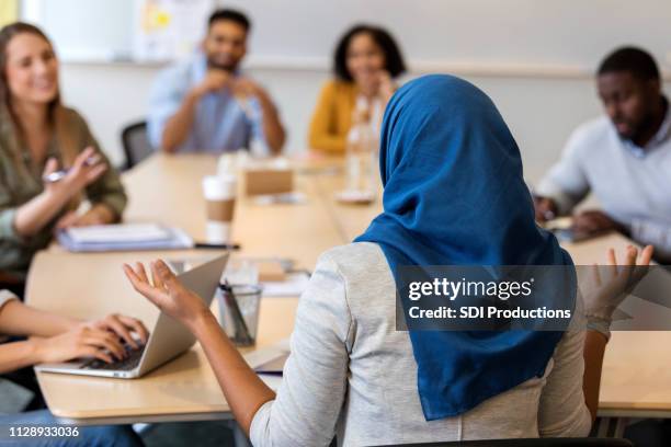 muslimische geschäftsfrau präsentiert ideen zu design-gruppe - hijab woman from behind stock-fotos und bilder