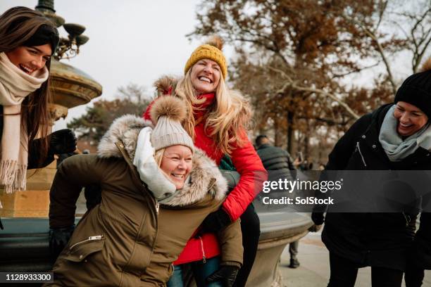 friends laughing together outside - new york central park fountain stock pictures, royalty-free photos & images
