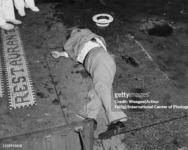 View of the body of gangster Dominick Didato on the sidewalk outside a restaurant on Elizabeth Street, New York, August 6, 1936. His hat and a...