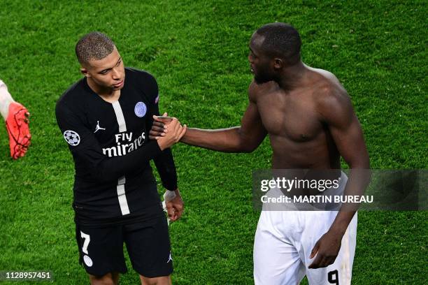 Paris Saint-Germain's French forward Kylian Mbappe shakes hands with Manchester United's Belgian forward Romelu Lukaku at the end of the UEFA...