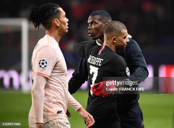 Manchester United's French midfielder Paul Pogba greets Paris Saint-Germain's French forward Kylian Mbappe at the end of the UEFA Champions League...