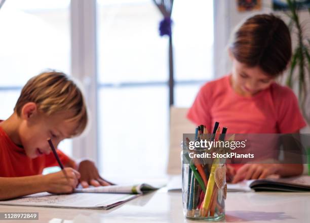 cerca de dibujo lápices de colores delante de los niños y niñas mientras hacen su tarea - familia con dos hijos fotografías e imágenes de stock
