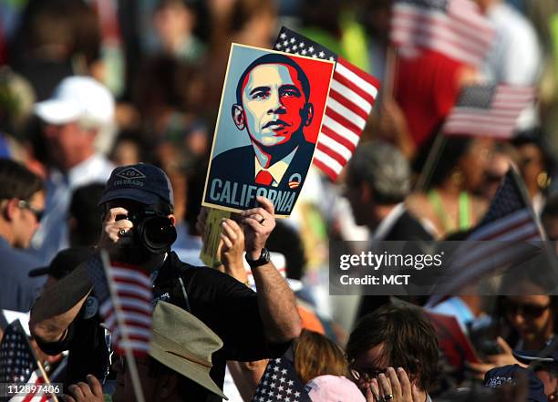 Delegate snaps a photograph while holding a sign supporting Democratic presidential candidate Barack Obama during the final day of Democrat National...
