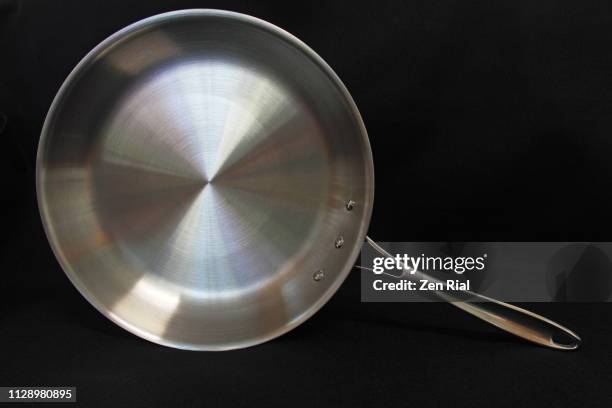 a ten-inch stainless steel frying pan on black background - frying pan from above stock pictures, royalty-free photos & images