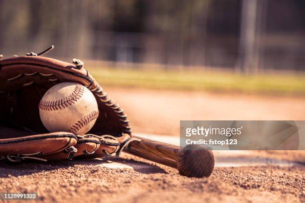 baseball season is here.  bat, glove and ball on home plate. - bastão de basebol imagens e fotografias de stock