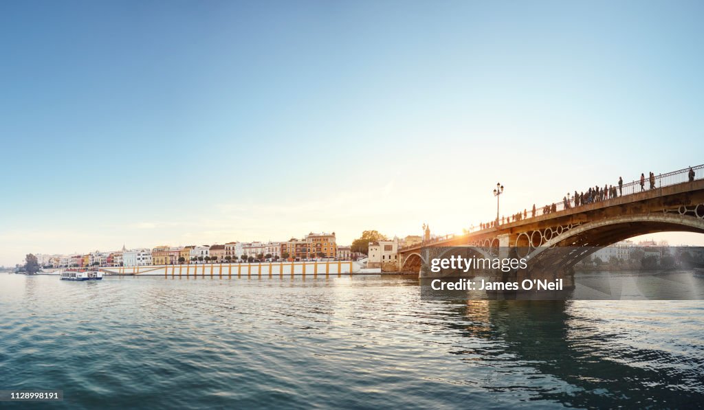 River Guadalquivir and The Isabel II Bridge at sunset, Seville, Spain
