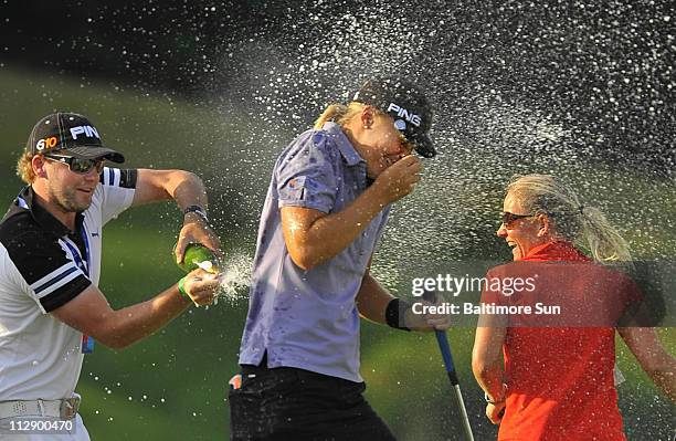 Anna Nordqvist, center, gets sprayed with champagne by friends Ryan Fisher, left, and golfer Louise Friberg, right, after the final putt on the 18th...