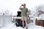 Mature man getting ready to grill while drinking beer during winter season