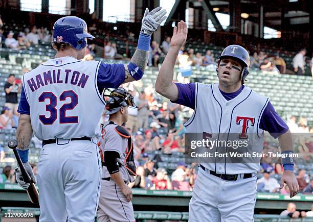 Texas Rangers' Josh Hamilton high-fives Ian Kinsler , who scored to break a tie in the bottom of the seventh inning during a double header at Rangers...