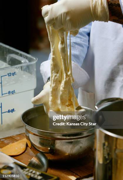 Stretch and pull and work the mozzarella. The cheese will look lumpy, with tiny grains of curd and small air bubbles.