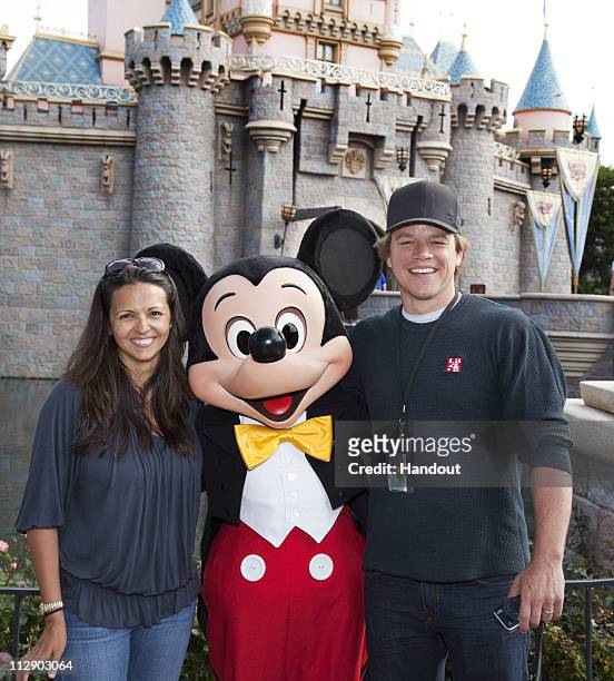 In this handout photo provided by Disney Parks, actor Matt Damon and his wife Luciana pose with Mickey Mouse at Sleeping Beauty Castle at Disneyland...