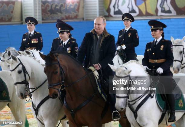 Russian President Vladimir Putin rides a horse while visiting the mounted police department on March 7, 2019 in in Moscow, Russia. Putin...